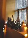 Selective focus of a small Eiffel Tower souvenir on the windowsill decorated with lights Royalty Free Stock Photo