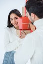 selective focus of smiling asian woman holding stack of wrapped christmas gifts together with boyfriend