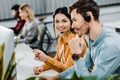 Selective focus of smiling call center operators and multiethnic colleagues behind Royalty Free Stock Photo
