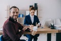 selective focus of smiling client with coffee to go pointing at businesswoman