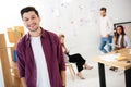 selective focus of smiling marketing manager looking at camera with multicultural colleagues behind Royalty Free Stock Photo