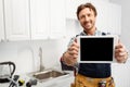 Focus of smiling plumber showing digital