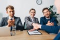 Selective focus of smiling recruiter shaking hand with employee