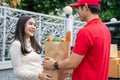 Selective Focus of smiling woman receiving a grocery bag from the courier