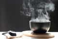 Selective focus of smoke rising with hot soup in cup and spoon o