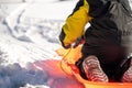 Selective focus on the snow boot of a child going down a hill on a sled Royalty Free Stock Photo