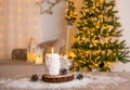 Selective focus on snowball pattern candle burning, decorated with pine tree wood disc, white snowflake decoration and fake snow. Royalty Free Stock Photo
