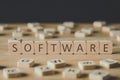 Focus of software lettering on cubes surrounded by blocks with letters on wooden surface isolated on black