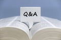 Selective focus of speech bubble written with Q&A on an open book Royalty Free Stock Photo