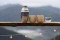 selective focus stainless steel thermal water bottle and bamboo coffee mug placed on a wooden balcony natural mountain background Royalty Free Stock Photo