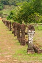 Selective focus of stone carved poles columns along walking path