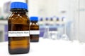 Selective focus of strong Hydrochloric acid solution in brown amber bottle. Blur laboratory backdrop with copy space.