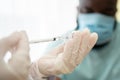 Selective focus of syringe, African American Wear a medical mask and being covid vaccinated for the prevention of coronavirus and