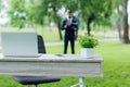 Focus of table with flowerpot and laptop in park