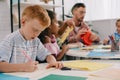 selective focus of teacher and multiracial preschoolers with colorful papers making paper applique Royalty Free Stock Photo