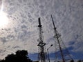 television station receiver and transmitter tower with a background of cumulus clouds Royalty Free Stock Photo