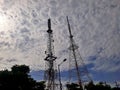 television station receiver and transmitter tower with a background of cumulus clouds Royalty Free Stock Photo