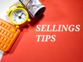 Selective focus.Text SELLINGS TIPS on a red background with calculator,clock and money.Business concept idea. Royalty Free Stock Photo