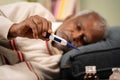 Selective focus on thermometer, sick bed ridden old man seeing temperature on thermometer