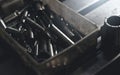 Selective focus on threaded tap, metal drill bit, and nut in old and dirty plastic toolbox. Old steel tool in box. Carbide tip Royalty Free Stock Photo