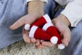 selective focus on three little santa hats in the hands of a child sitting on the floor in jeans, top view Royalty Free Stock Photo