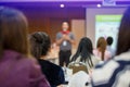 Selective focus to business woman with blurry man speaker for meeting or seminar event in the meeting room. They are brain