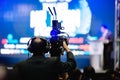 Selective focus to cameraman and video camera set are recording to speaker and audience in conference hall or seminar event Royalty Free Stock Photo