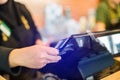 Selective focus to the cashier is swiping the credit card or member card at the card reader with the cash register machine in the Royalty Free Stock Photo