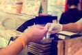 Selective focus to cashier take banknote from consumer hand