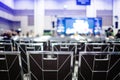 Selective focus to chairs in auditorium for shareholders` meeting or seminar event with blurry projector and white screen, blurre Royalty Free Stock Photo