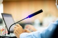 Selective focus to desktop wireless conference microphones with blurry businessman wearing mask in a meeting room