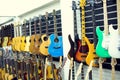 Selective focus to electric guitar with blurry guitars are hanging in musical showroom Royalty Free Stock Photo
