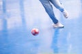Selective focus to foot of futsal player with blurry red ball. Indoor soccer sports hall Royalty Free Stock Photo