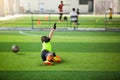 Selective focus to goalkeeper is jumping to catching the soccer ball. Blurry ball after going out from hands of goalkeeper on Royalty Free Stock Photo
