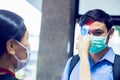 Selective focus to hand of staff holding digital thermometer to check fever visitor at Information counter for scan and protect