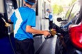 Selective focus to Petrol pump filling nozzles with hand of staff at the gas station