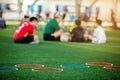 Selective focus to ring ladder marker and cone are soccer training equipment on green artificial turf with blurry kid players Royalty Free Stock Photo