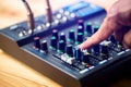 Selective focus to sound electronics mixer and equalizer with hand to turning and adjusting button and slide volume Royalty Free Stock Photo