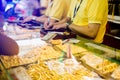 Selective focus to staff are counting banknote, customers are buying gold jewelry in the gold shop