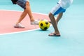 Selective focus to yellow ball with blurry futsal player playing