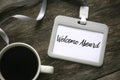 Selective focus and top view of a black coffee together with lanyard and name tag written with Welcome aboard on wooden background