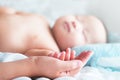 Selective focus touching feeling, tiny fingers newborn baby hold mother hands for protection, safety, sleeping on the bed,relax Royalty Free Stock Photo