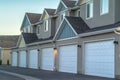 Selective focus of townhomes with white garage doors against mountain and sky Royalty Free Stock Photo