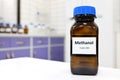 Selective focus of toxic methanol or methyl alcohol in glass bottle inside a laboratory.
