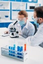 selective focus of tubes with reagents and scientists at workplace Royalty Free Stock Photo