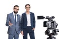 selective focus of two newscasters taking and looking at camera, Royalty Free Stock Photo