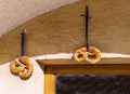 Selective focus on two pretzels with blue ribbons on the bakery wall. Traditional beer snack Royalty Free Stock Photo