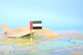 Selective focus of UAE flag in blurry world map and wooden airplane model. UAE as travel and tourism Royalty Free Stock Photo