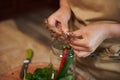 Details: Housewife hands putting umbrella dill into a glass jar while canning spicy chili peppers for the winter