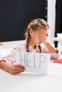 Selective focus of upset schoolgirl holding